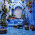 a blue alley with potted plants and a bench, tours from rabat