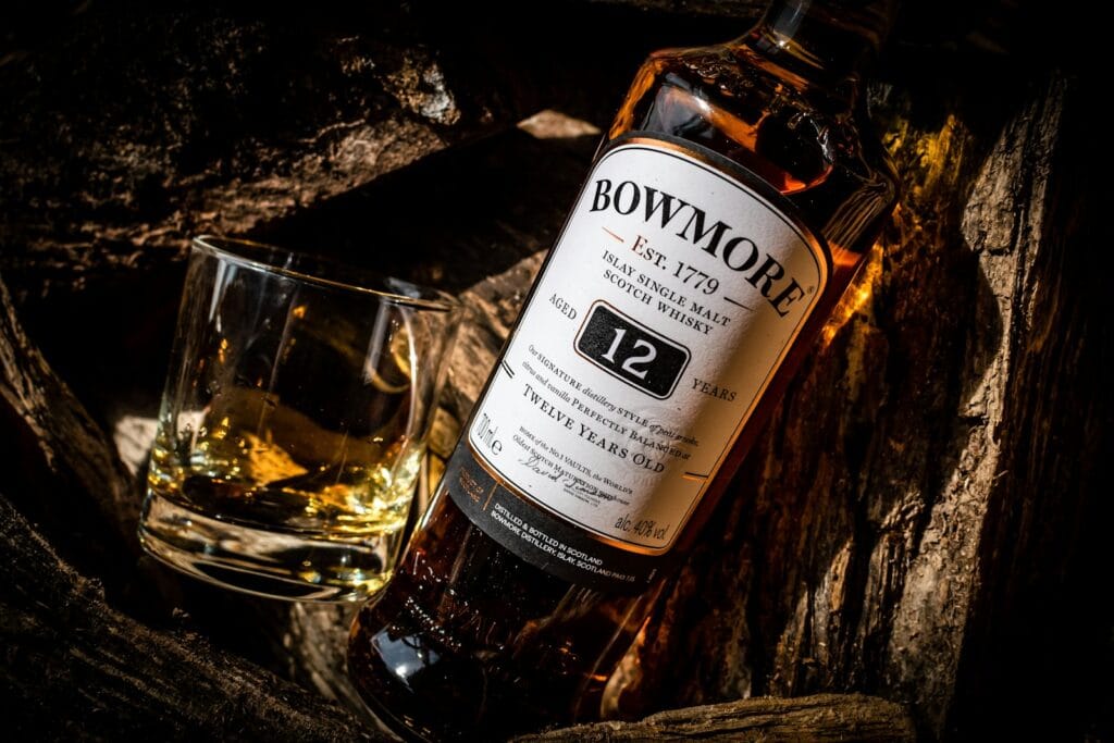 a bottle of bowmore whiskey next to a glass