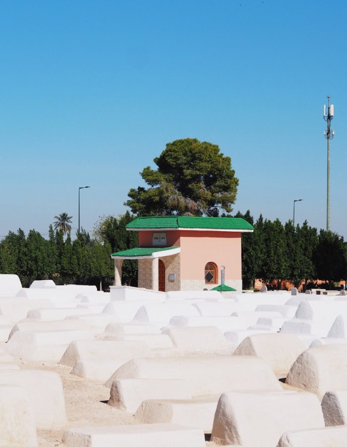 a building with a green roof surrounded by white sand