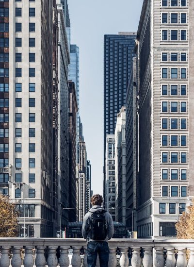 man standing beside rail during daytime