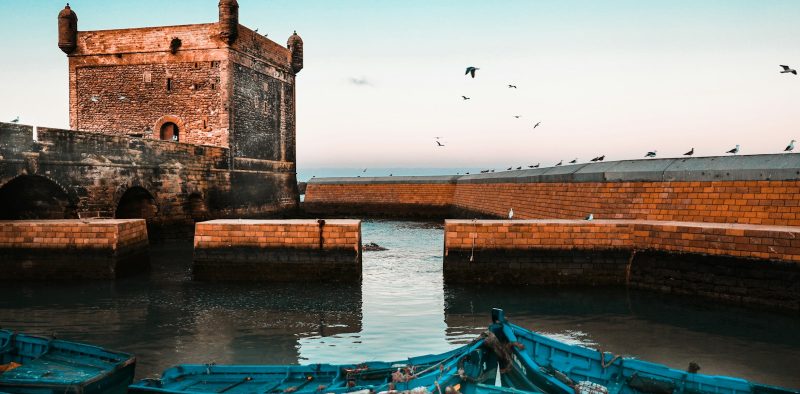 brown brick building near body of water during daytime