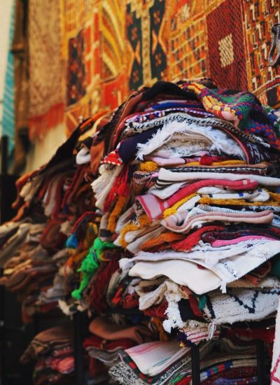 a pile of cloths on a stand in front of a building