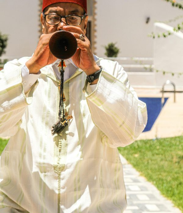 Moroccan Musical Instruments: A Guide to Morocco’s Traditional Sounds 3 A musician in traditional Moroccan attire plays the flute outdoors in sunny Rabat.moroccan musical instruments