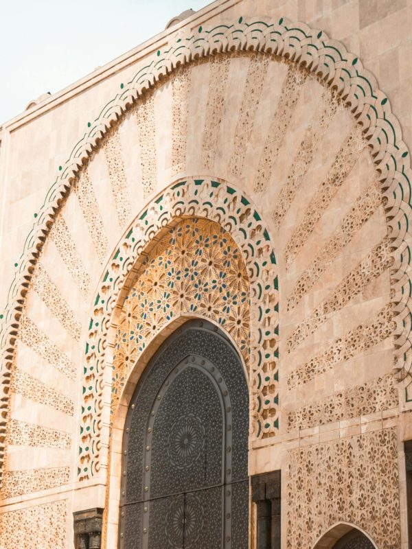 Intricate stone facade of Hassan II Mosque in Casablanca, Morocco.