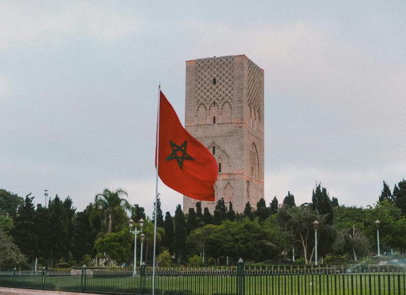 Capture of the iconic Hassan Tower with the Moroccan flag in Rabat, showcasing historic architecture.