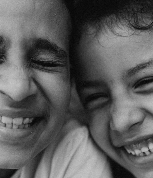 Morocco Family Tours 3 A heartwarming black and white close-up of two children's joyful faces with genuine smiles.morocco family tours