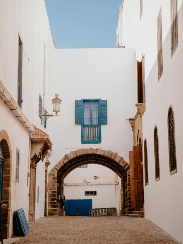 pexels-photo-29216714-29216714 Explore a serene alleyway in Essaouira with iconic white walls and vibrant blue shutters.