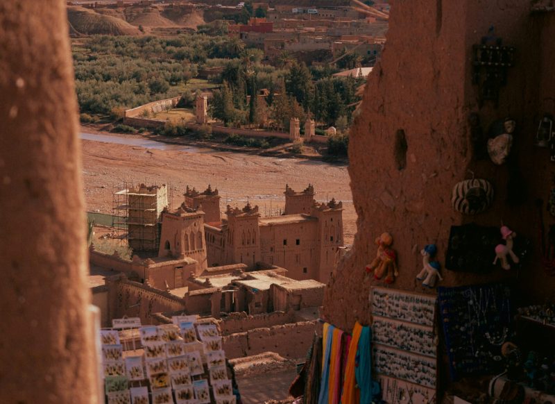 Scenic view of Aït Benhaddou, a traditional Berber village, with market stalls in the foreground.ouarzazate morocco​