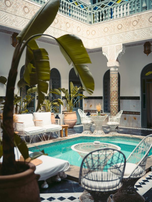 Luxurious Moroccan courtyard in Marrakesh with a pool and ornate decor.