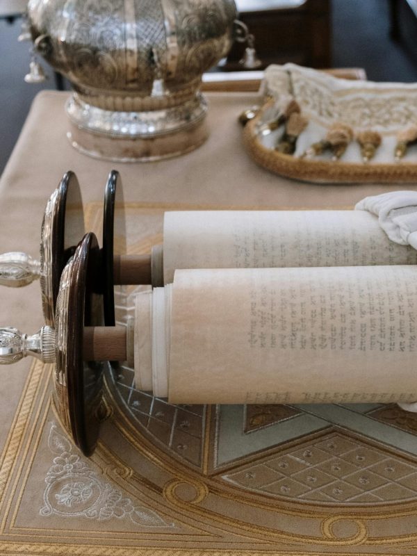 Sefer Torah scroll displayed on a bimah in a synagogue setting, showcasing rich cultural heritage.