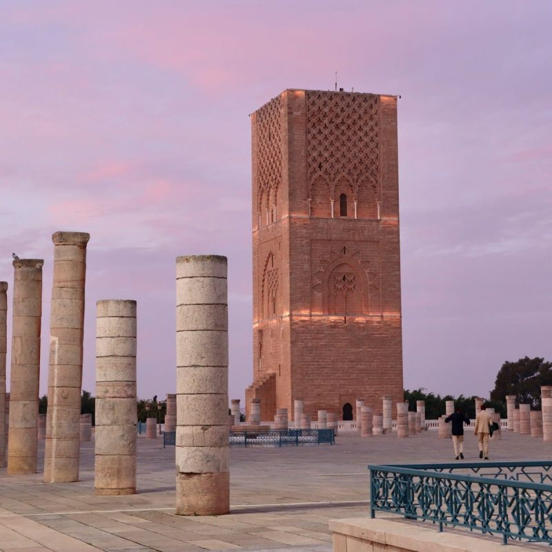 A group of pillars sitting next to a tall building, things to do in rabat