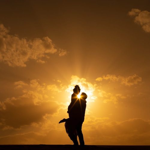 a couple of people that are standing in the sun