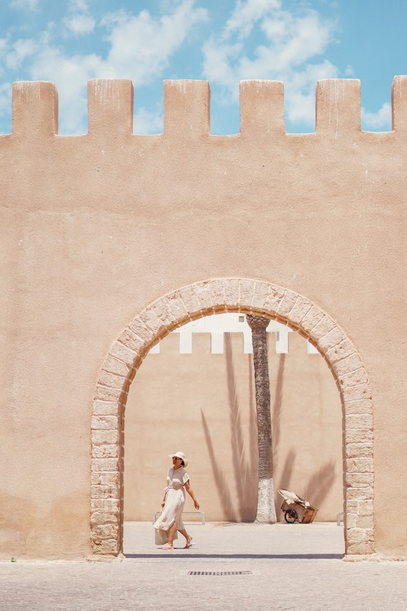 a woman walking in front of a stone [UNK]