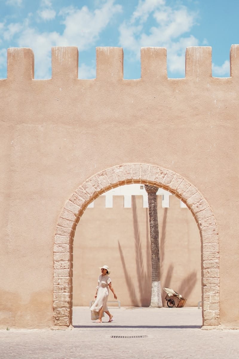 a woman walking in front of a stone [UNK]