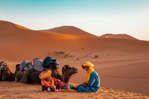 man in yellow robe sitting on brown sand during daytime, Day Tours from Tangier