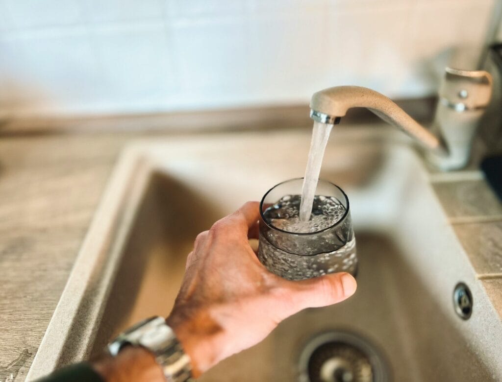 a hand holding a glass of water.Can I Drink the Tap Water in Morocco