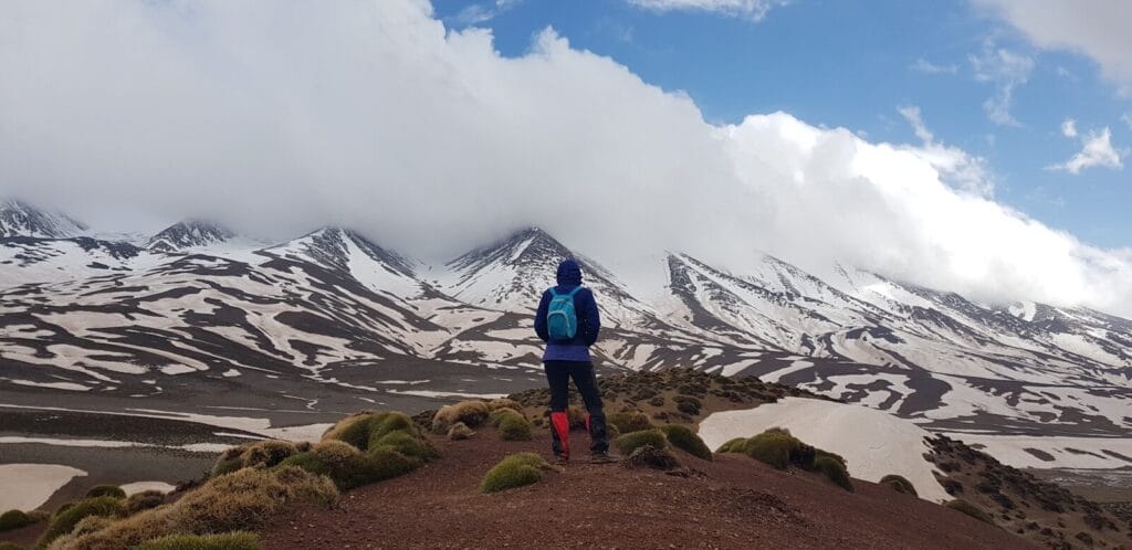 man standing on mountain with blue backpack during daytime.does it snow in morocco​
