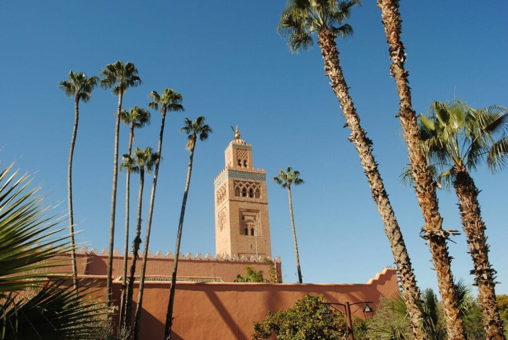 beige concrete building near palm trees under blue sky during daytime.weather in morocco in april