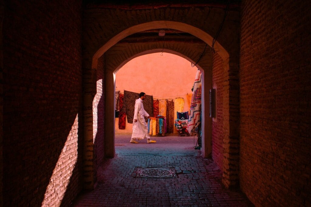 A person walks through a brick archway.people of Morocco
