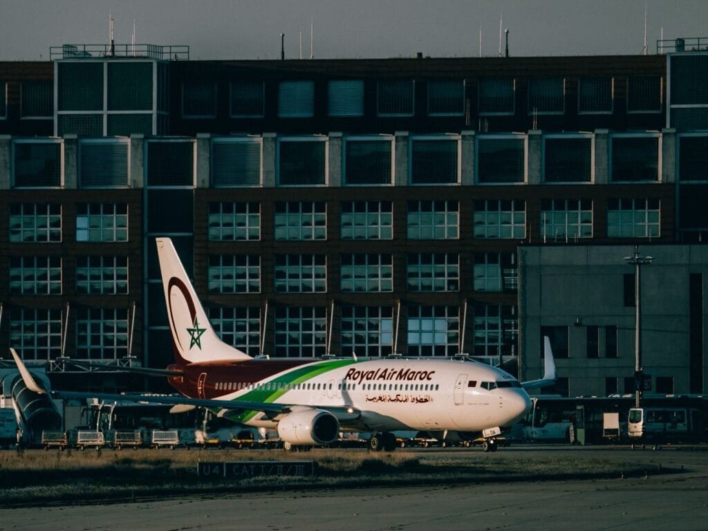 Royal Air Maroc aircraft parked at an airport apron with terminal building in the background.Marrakech Casablanca distance